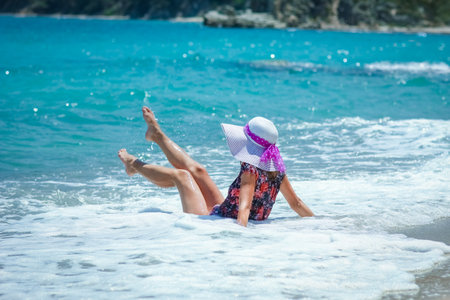 Happy girl on the shore of the sea in travel vacationの写真素材