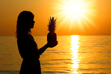 happy girl man and pineapple in hands silhouette by the sea travelの写真素材