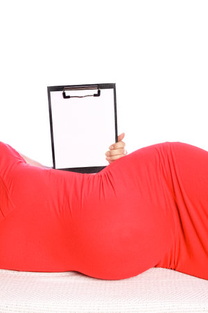Happy pregnant girl lies on white backgroundの写真素材