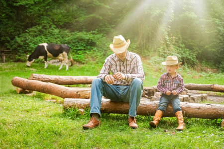 happy child with cowboy parent in nature in the fieldの写真素材