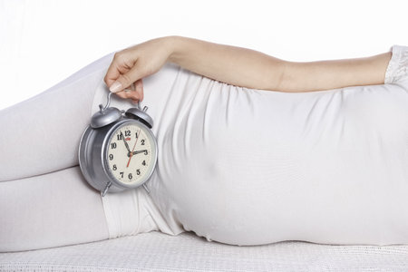 Happy pregnant girl lies on white backgroundの写真素材