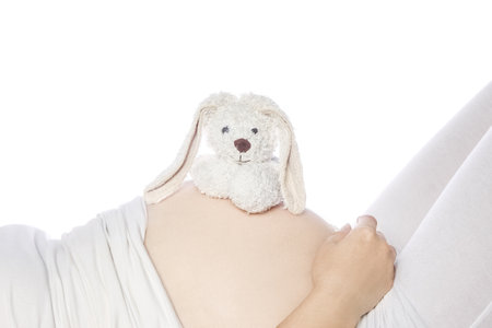 Happy pregnant girl lies on white backgroundの写真素材
