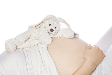 Happy pregnant girl lies on white backgroundの写真素材
