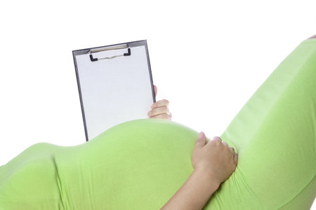 Happy pregnant girl lies on white backgroundの写真素材