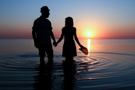 Happy couple by the sea at sunset on travel silhouette in natureの写真素材