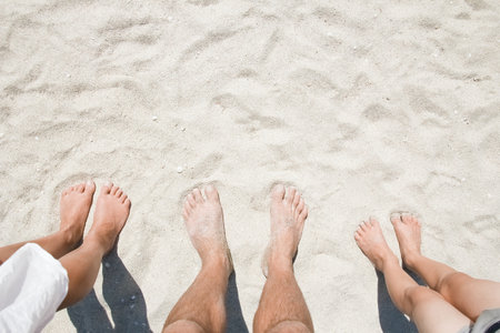 Feet on the sand of happy people by the sea on nature travel