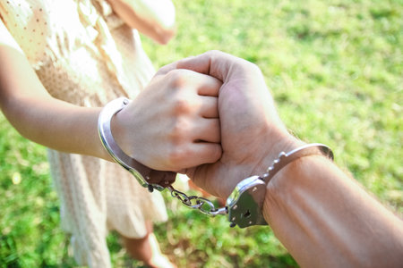 man handcuffed outdoors in the parkの写真素材