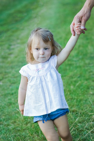 beautiful hands of parent and child outdoors in the parkの写真素材