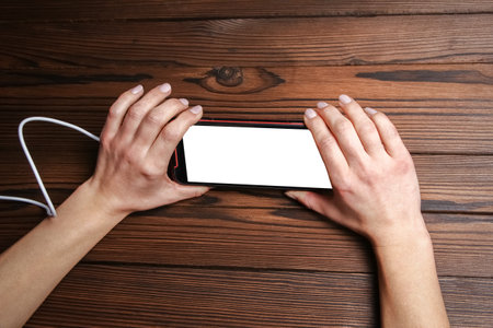 phone with hands addiction on a wooden backgroundの写真素材