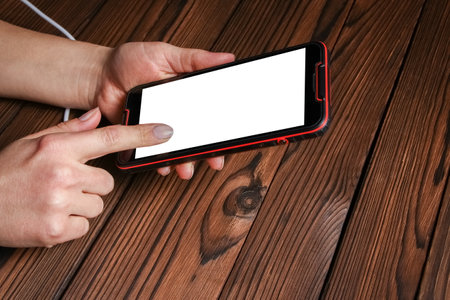 phone with hands addiction on a wooden backgroundの写真素材