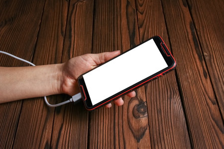 phone with hands addiction on a wooden backgroundの写真素材