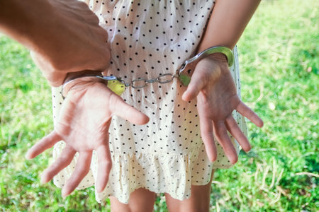 man handcuffed outdoors in the parkの写真素材