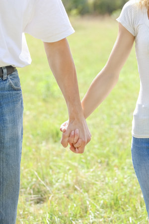 Hands of a happy couple in love outdoors in the summer parkの写真素材