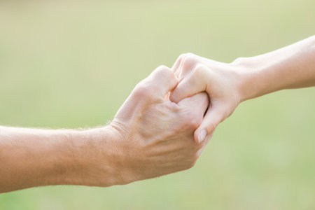 Hands of a happy couple in love outdoors in the summer parkの写真素材