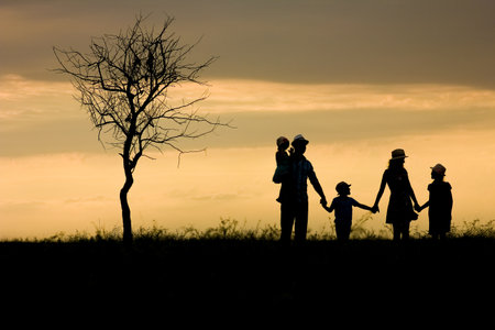 Happy family silhouette on nature in park backgroundの写真素材