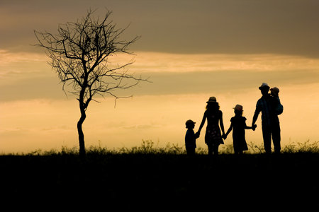 Happy family silhouette on nature in park backgroundの写真素材