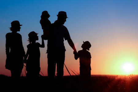 Happy family by the sea at sunset in travel silhouette in natureの写真素材