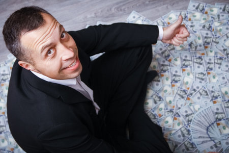 Happy guy with money in his hands for the development of shopping business and a great tripの写真素材