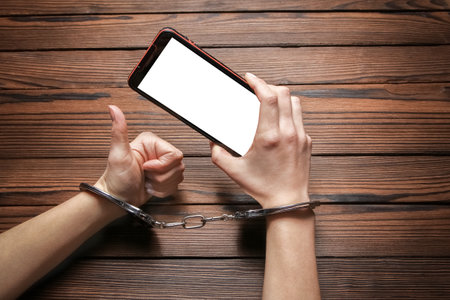 phone with hands addiction on a wooden backgroundの写真素材