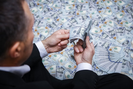 Happy guy with money in his hands for the development of shopping business and a great tripの写真素材