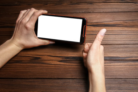 phone with hands addiction on a wooden backgroundの写真素材