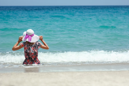 Happy girl on the shore of the sea in travel vacationの写真素材