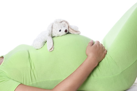 Happy pregnant girl lies on white backgroundの写真素材