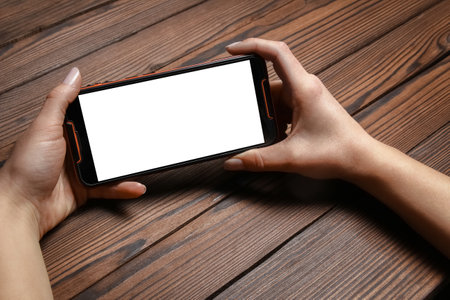 phone with hands addiction on a wooden backgroundの写真素材