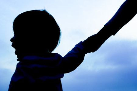 happy parent with child in the park outdoors silhouetteの写真素材