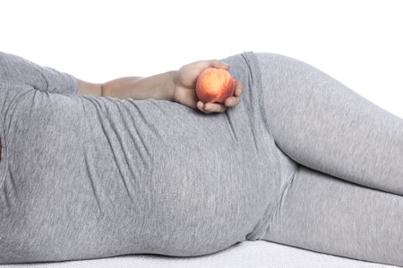 Happy pregnant girl lies on white backgroundの写真素材