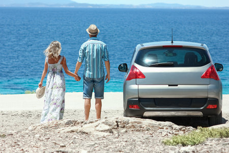 happy couple cars by the sea in nature weekend travelの写真素材