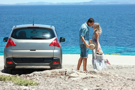 happy couple cars by the sea in nature weekend travelの写真素材