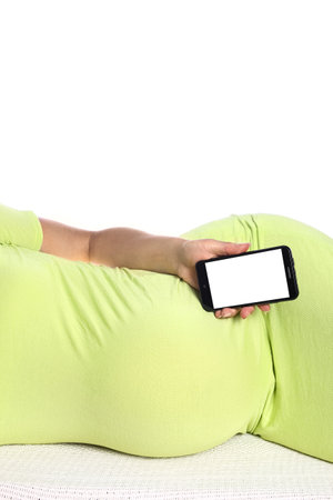Happy pregnant girl lies on white backgroundの写真素材