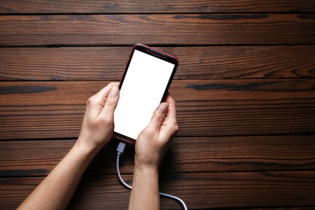 phone with hands addiction on a wooden backgroundの写真素材
