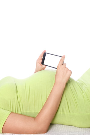 Happy pregnant girl lies on white backgroundの写真素材