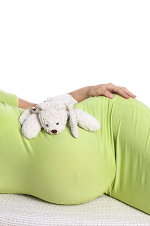 Happy pregnant girl lies on white backgroundの写真素材