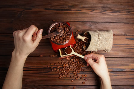 a female  hands and coffee grinderの写真素材