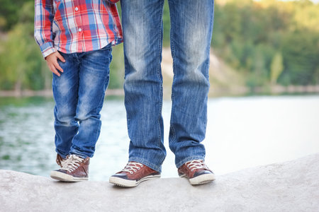Feet of happy parent and child in nature in the park travelの写真素材
