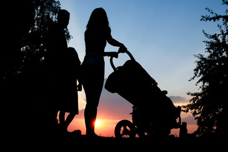 happy couple with child silhouette on a sunset natureの写真素材