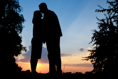 happy couple together at sunset silhouette of natureの写真素材