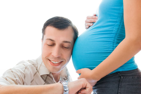 pregnant girl on a white background with her husbandの写真素材