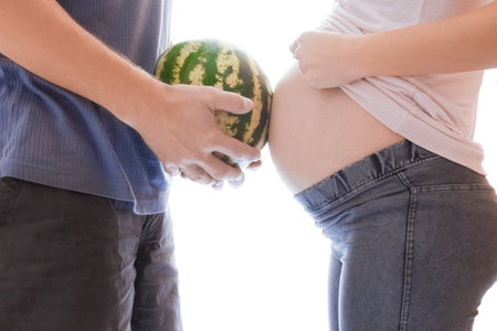 happy man with watermelon and a pregnant woman on a white background
