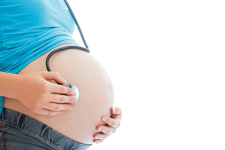 pregnant girl on a white background with statoscopeの写真素材