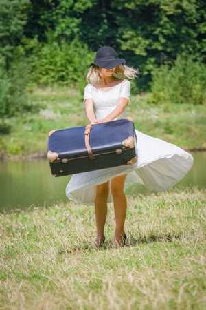 happy girl with a suitcase outdoors at the parkの写真素材