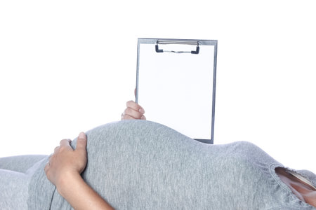 Happy pregnant girl lies on white backgroundの写真素材