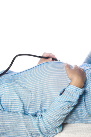Happy pregnant girl lies on white backgroundの写真素材