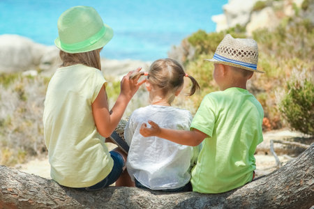 happy kids playing on greek sea shore backgroundの写真素材