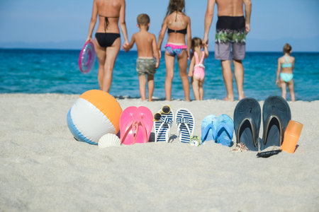 happy family on the sea with slippers on nature backgroundの写真素材