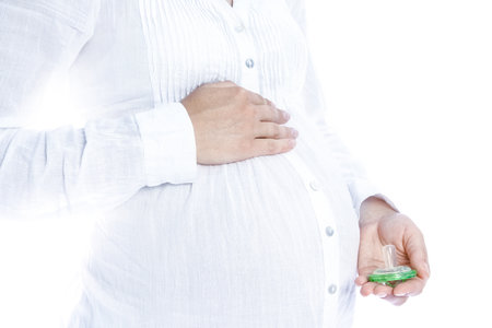 Happy pregnant girl lies on white backgroundの写真素材