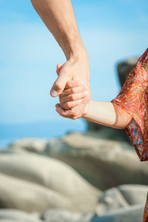 beautiful hands of parent and child by the seaの写真素材